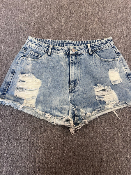 waisted distressed denim shorts featuring a light acid wash, heavy fraying at the raw hemline, and distinct ripped window cutouts on both legs.